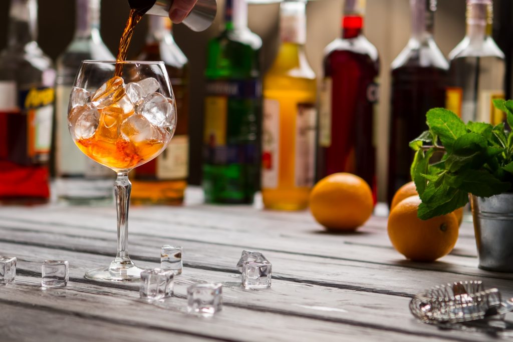 Baarimikko kaataa juomaa lasiin